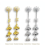 Gold-tone and silver-tone Starlit Melody long earrings with sparkling starburst tops and cascading ghungroo bells on white