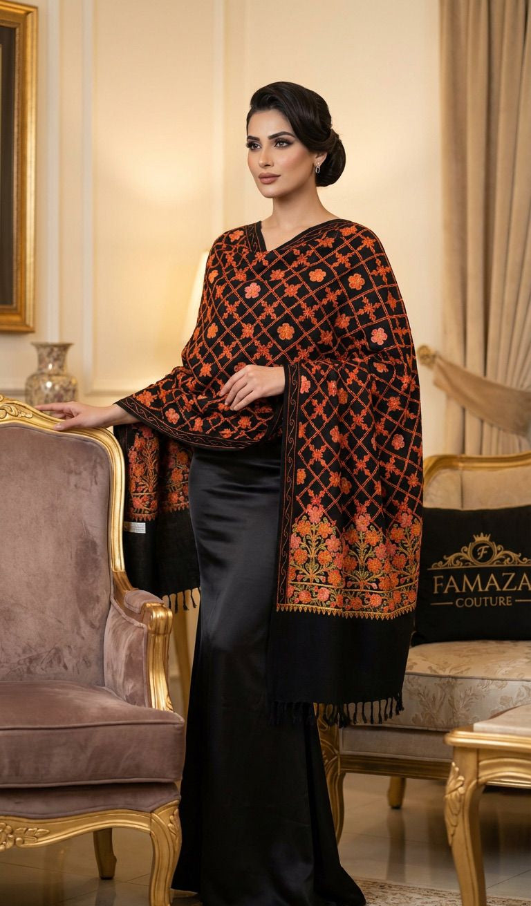 Woman wearing a black and orange patterned shawl in an elegant room.