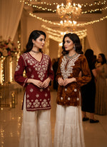 Two mannequins wearing traditional outfits in a store setting.