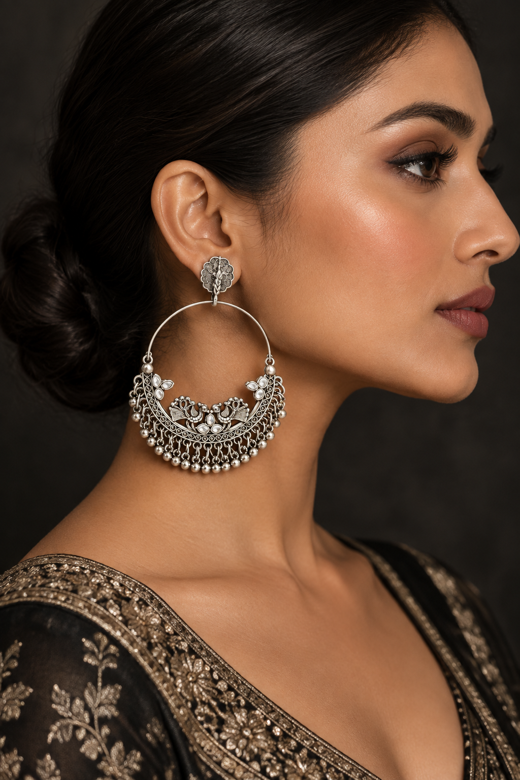 White worn on model: Model wearing silver-tone peacock chandbali earrings with white accents and ghungroo fringe against a dark background.