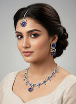 white American diamond stones with blue saffire stone in the centre on this jewellery set includes necklace, earrings and maang tikka by famaza couture 