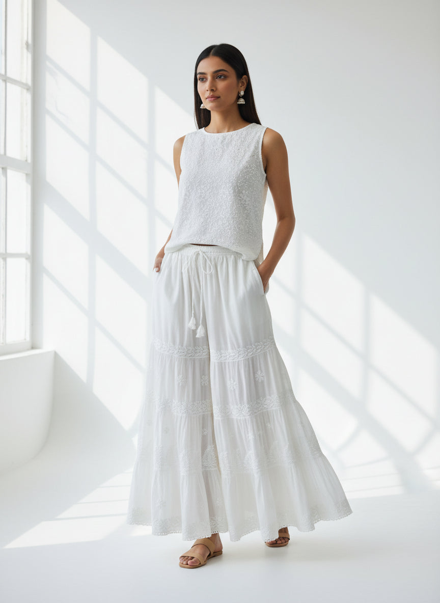 white cotton flared trousers with chikankari embroidery work and with pockets on both sides of the belt