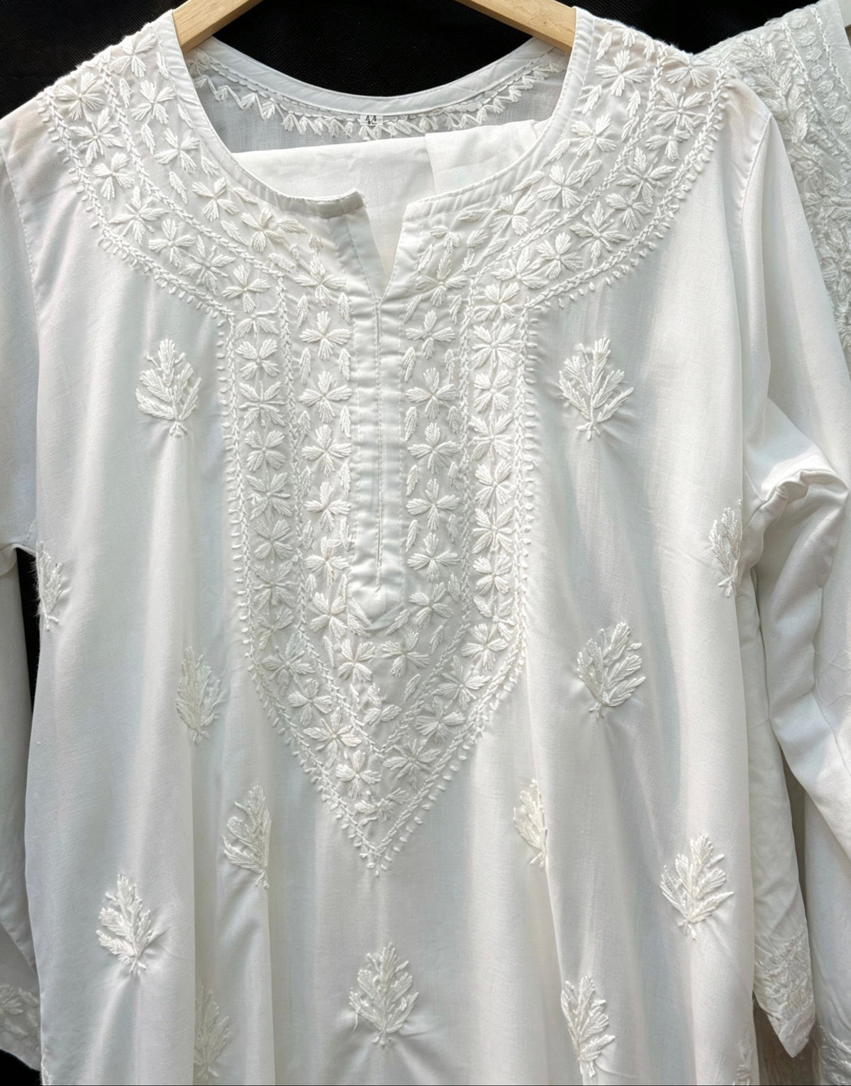 white embroidered kurti neckline embroidery is in focus for the customers to understand the neck embroidery. 