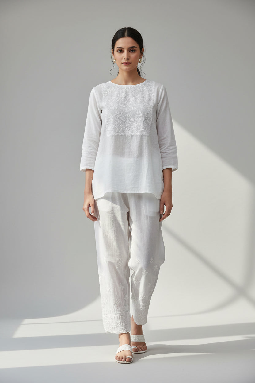 white mulmul fabric straight loose pnats with white hand embroidered with ankle cut design. 