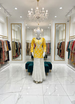 Mannequin wearing a yellow floral dress in a store setting with various clothing items around.