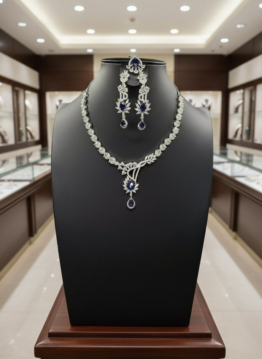 with semi-precious American diamonds and blue saffaire central stones a rhodium-plated brass necklace,earrings and maang tikka by famaza couture