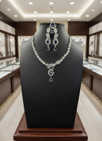 with semi-precious American diamonds and blue saffaire central stones a rhodium-plated brass necklace,earrings and maang tikka by famaza couture